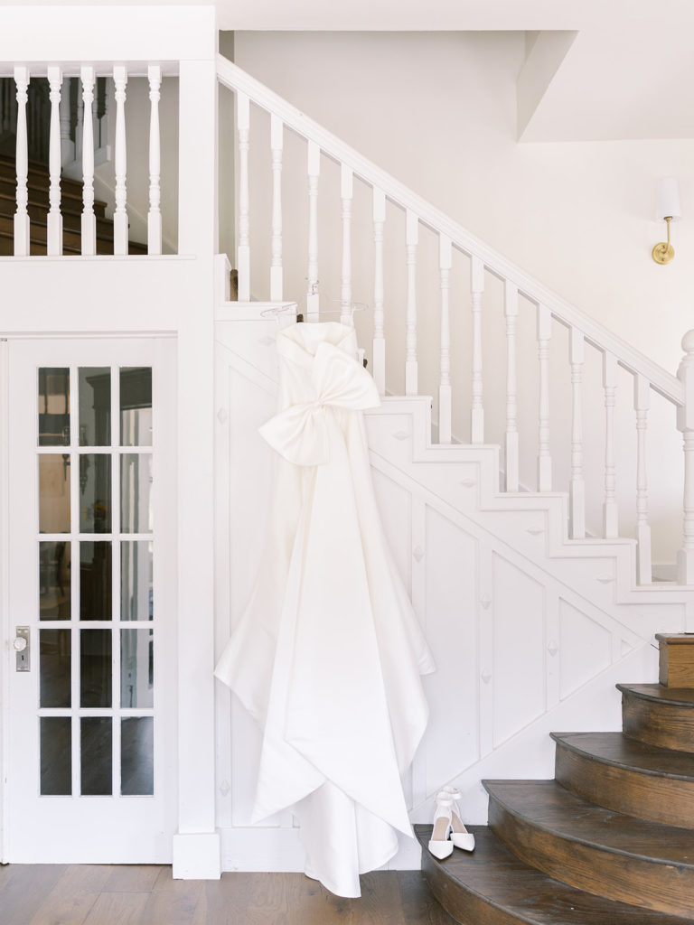 White wedding dress hanging from staircase